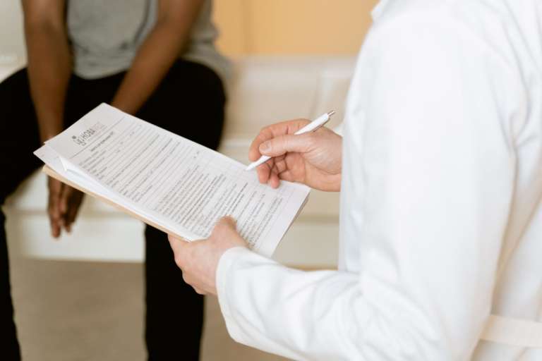 Clinician reviewing a form with a person seated across from them.